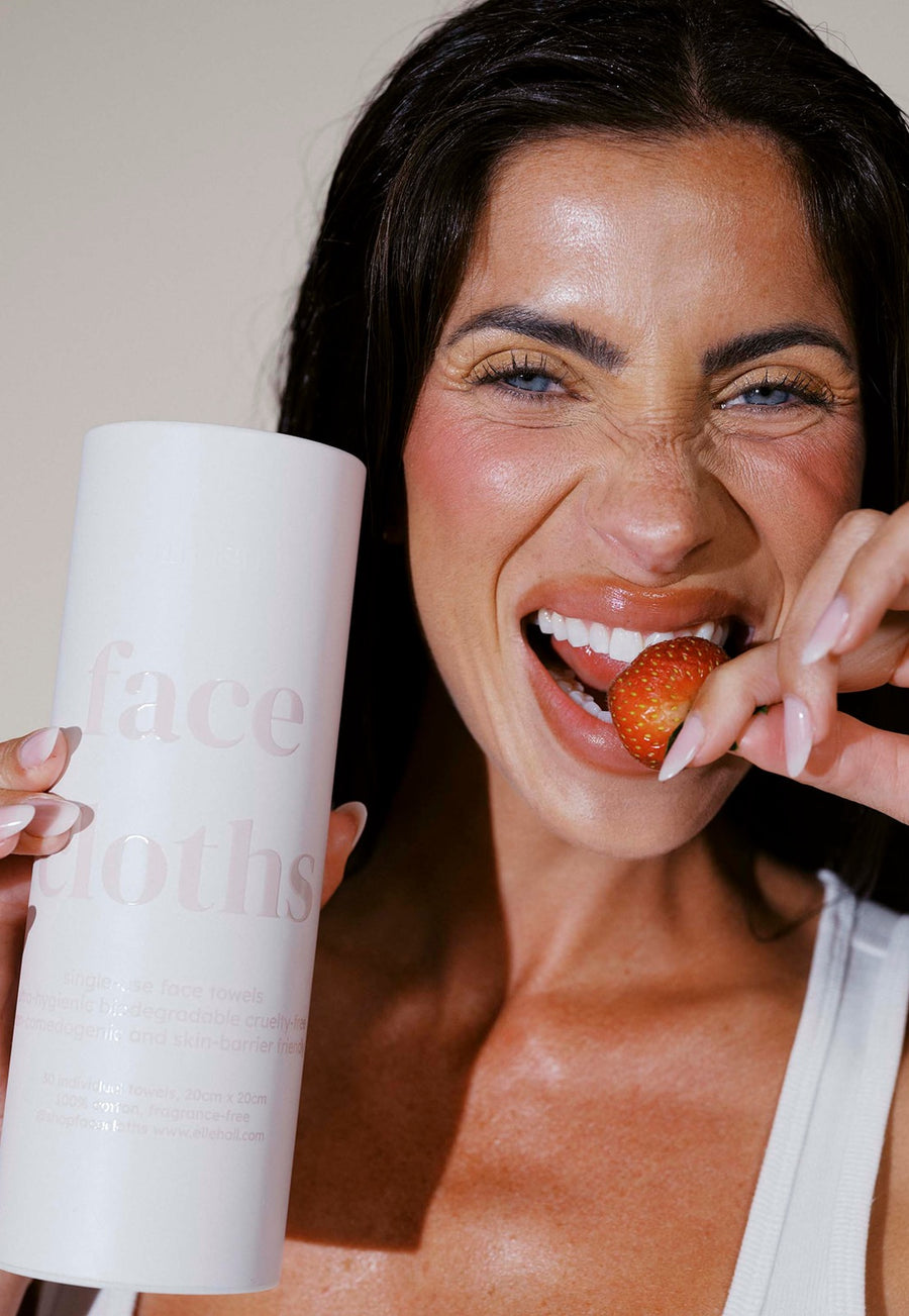 Smiling with a strawberry and a tube of Face Cloths