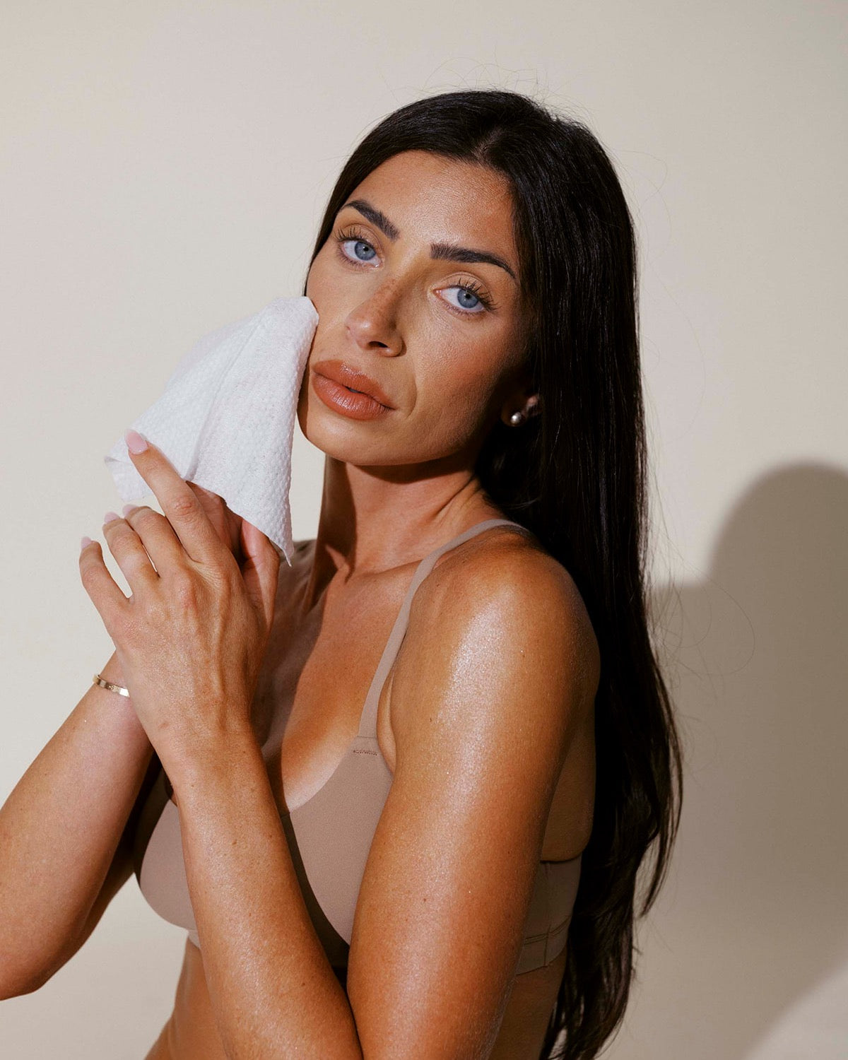 Patting her face dry with a single-use Face Cloths towel
